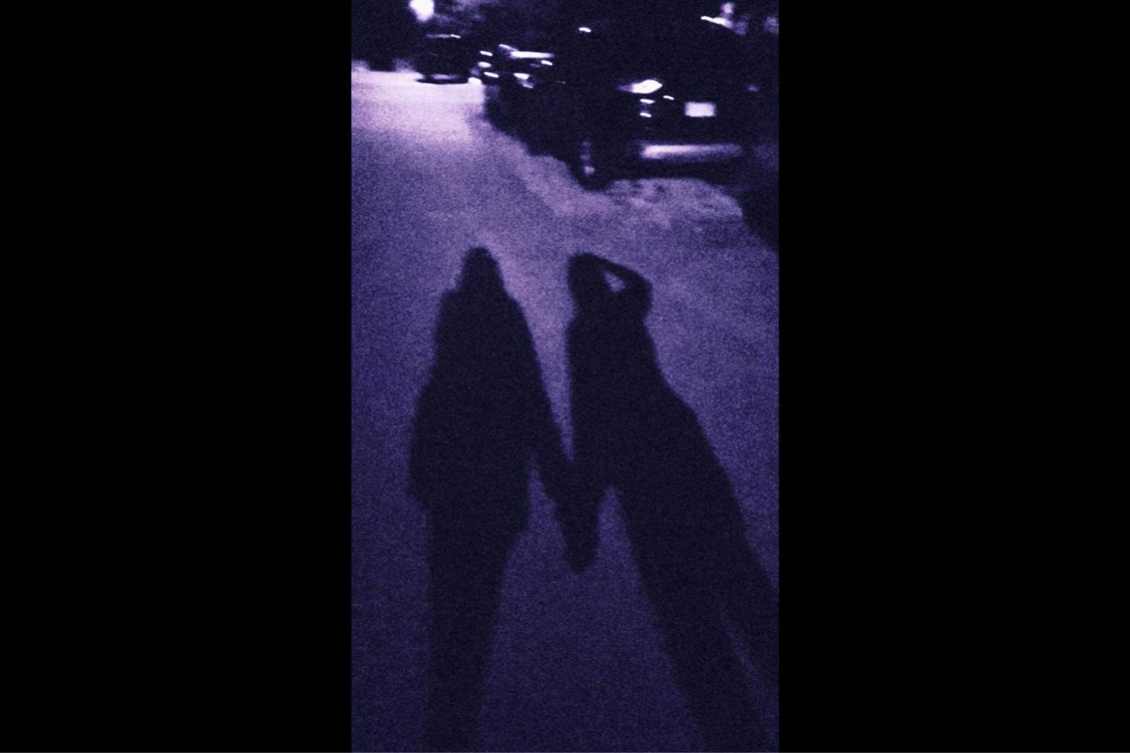 Shadow of two figures on the road.