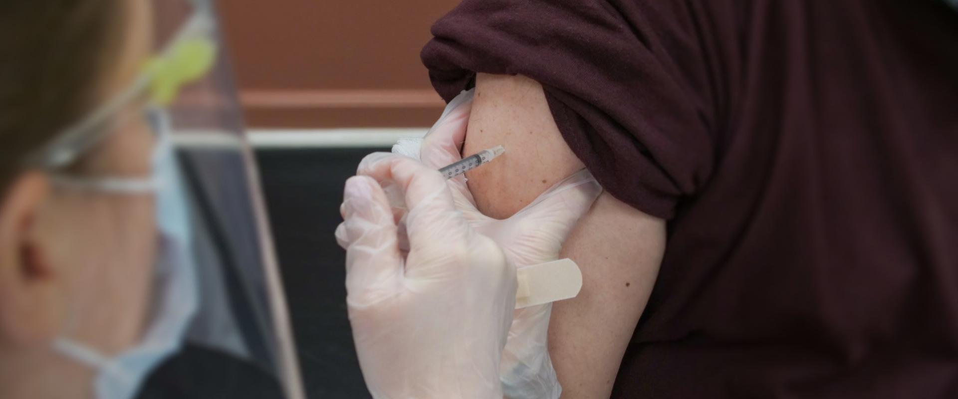 Medical staff injecting persons arm